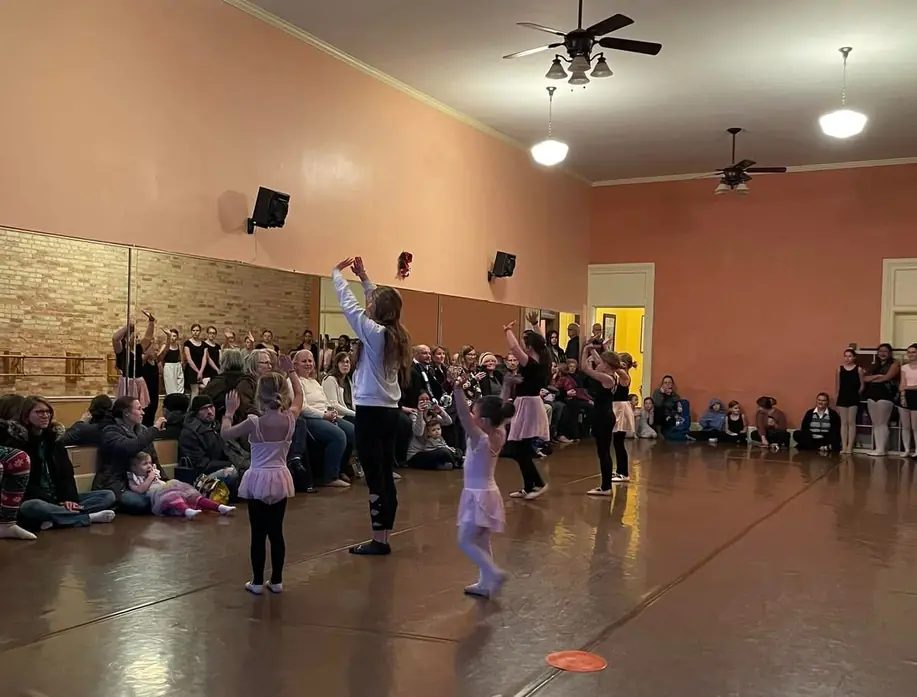 Families seated along the wall watching a class in the studio